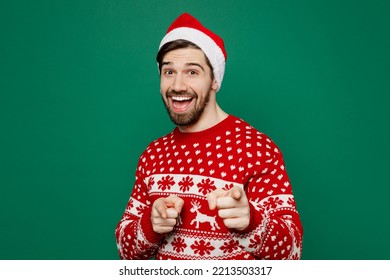 Merry young man wear red warm knitted sweater Santa hat posing point index finger camera on you motivating encourage isolated on plain dark green background. New Year 2023 holiday celebration concept - Shutterstock ID 2213503317