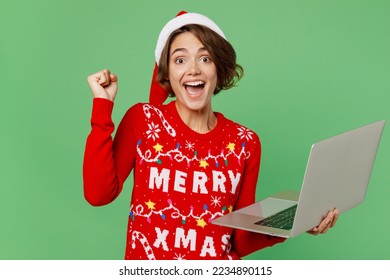 Merry young IT woman wear knitted xmas sweater Santa hat posing work hold use laptop pc computer do winner gesture isolated on plain pastel light green background Happy New Year 2023 holiday concept - Powered by Shutterstock