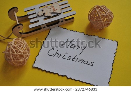 merrychristmas card next to deco on the yellow background 