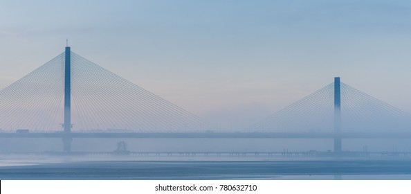 Mersey Gateway cable stayed bridge on A533 in foggy blue winter morning, Warrington, Chesire, England