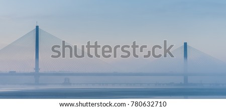 Mersey Gateway cable stayed bridge on A533 in foggy blue winter morning, Warrington, Chesire, England