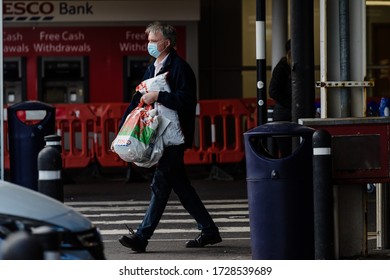 MERTHYR TYDFIL, WALES - 11 MAY 2020 - Man With Face Mask On Is Seen Leaving A Tesco Extra Super Store.