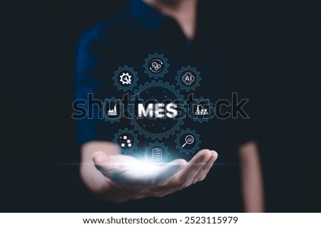 MES - Manufacturing Execution System Concept. A person presents a glowing MES icon with digital symbols related to manufacturing, automation, industrial processes, technology in production management,