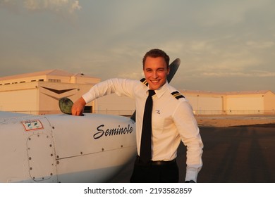 MESA, ARIZONA, USA - 22 July 2022: Commercial Student Pilot Checking The Oil On One Of The Engines Of A Twin Engine Piper Seminole On The Ramp At Falcon Field Airport 