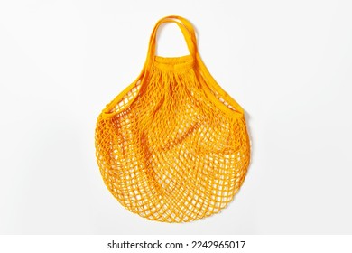 mesh grocery bag. Reusable bag. Vegetarianism, raw food diet, conscious consumption, grid. mesh bag in orange on a white background. View from above - Powered by Shutterstock