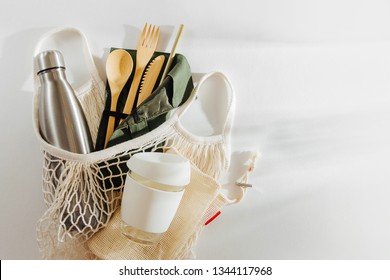 Mesh market bag with bamboo cutlery, reusable coffee mug  and  water bottle. Sustainable lifestyle.  Plastic free concept.