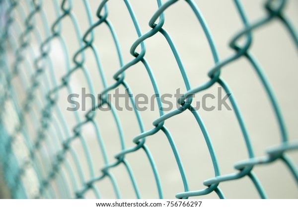 Mesh wire on\
blurry background, selective\
focus.