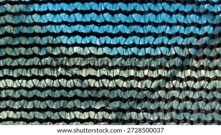 Meshwork of high-density polyethylene (HDPE) on a chain-link fence; a very close closeup