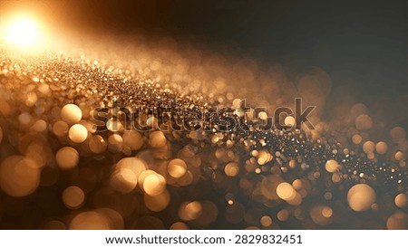 A mesmerizing abstract background featuring a cascade of golden glitter particles illuminated by a bright light source, with soft, out-of-focus bokeh effects.