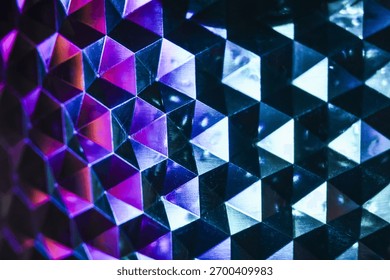 Mesmerizing abstract background with geometric pattern of vibrant purple and blue triangles. This futuristic design has cool neon light effect on dark reflective surface