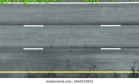 A mesmerizing aerial view of a pristine, empty intercity motorway, glistening under the sun, invites you to embark on a journey of endless possibilities. Drone aerial view. Road background.
