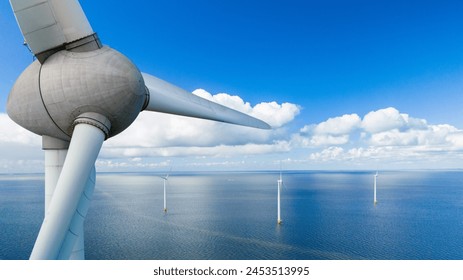 A mesmerizing aerial view of a wind farm in the ocean, with rows of windmill turbines gracefully spinning in the spring breeze, harnessing the power of the wind, green energy in the Netherlands - Powered by Shutterstock