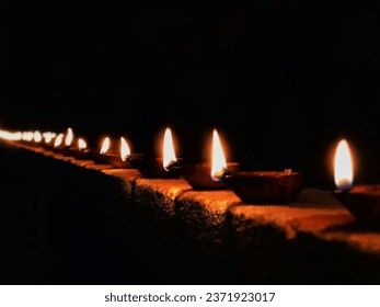 A mesmerizing array of flickering oil lamps casting a warm, golden glow.