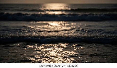 A mesmerizing close-up of ocean waves at dusk, with the setting sun's golden light reflecting brilliantly on the water's surface, creating a sparkling path of light across the dark sea.
