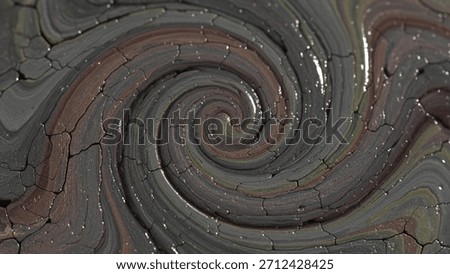 A mesmerizing digital artwork featuring a dark, textured spiral. The swirling pattern resembles wet, cracked mud or clay, creating a hypnotic and gritty abstract background.