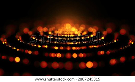 A mesmerizing display of bokeh lights creating concentric circles of warm orange and yellow hues against a deep black backdrop.