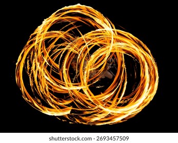 A mesmerizing fire dance captured in motion, creating golden trails of light against the dark night.