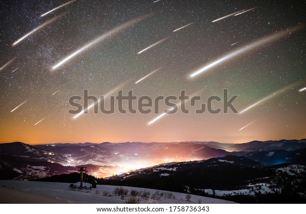Mesmerizing landscape of falling stars on\
background of starry sky on shining village are located among high\
mountain ranges on frosty winter night. Concept mysticism of UFO\
and abnormal\
phenomenon