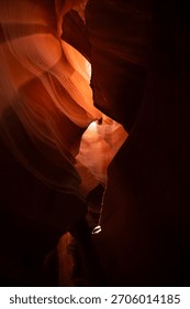 Mesmerizing sandstone formations inside Antelope Canyon, where soft beams of sunlight reveal the canyon’s swirling textures and radiant orange tones. The sculpted rock curves create an abstract, dream