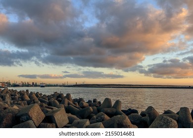 A mesmerizing scene of the cloudy blue sunset sky at the port of Klaipeda, Lithuania with rocks