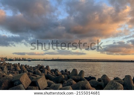A mesmerizing scene of the cloudy blue sunset sky at the port of Klaipeda, Lithuania with rocks