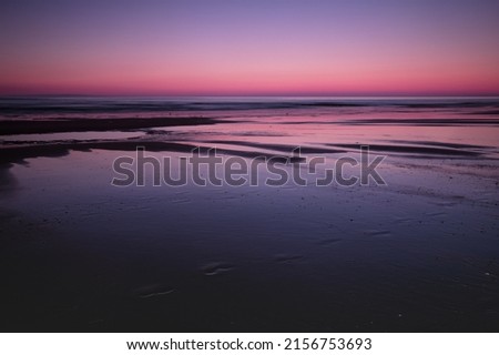 A mesmerizing scene of water by pink and blue sunset on the horizon in Cromer Beach, Norfolk, UK