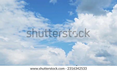 A mesmerizing sight unfolds as beautiful white clouds float gracefully in the vast expanse of the blue sky. The fluffy clouds create a serene and tranquil atmosphere