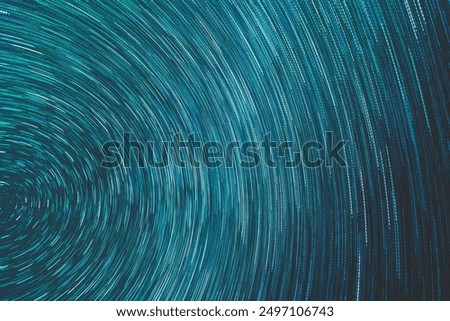 A mesmerizing star trails image created from a combination of 100 long-exposure photos. The sky is filled with concentric arcs of starlight, showcasing the Earth's rotation in a celestial dance.