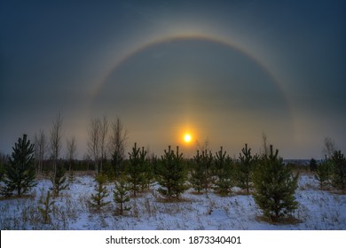 A mesmerizing sunset was observed on November 27, 2020 in the Urals (Russia). A multicolored arc from the sun is located on half of the sky. This rare phenomenon is a halo. Winter landscape with halo