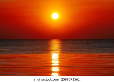 A mesmerizing sunset over the ocean, casting golden and orange hues across the sky and water. The sun’s reflection creates a serene and warm atmosphere.