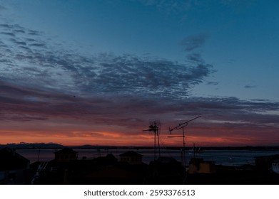 A mesmerizing sunset over Lisbon’s rooftops, where warm hues meet the cool evening sky above the Tagus River.