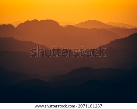 A mesmerizing view of the high hills on a foggy day at sunset
