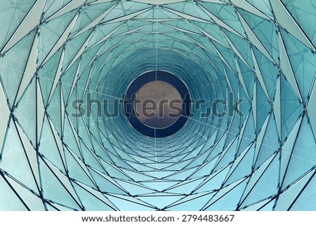 A mesmerizing view looking up through a geodesic dome structure with repeating triangular glass panels and metal framework creating a tunnel effect