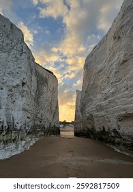 A mesmerizing view of narrow chalk cliffs framing a sandy pathway that leads to the horizon. 