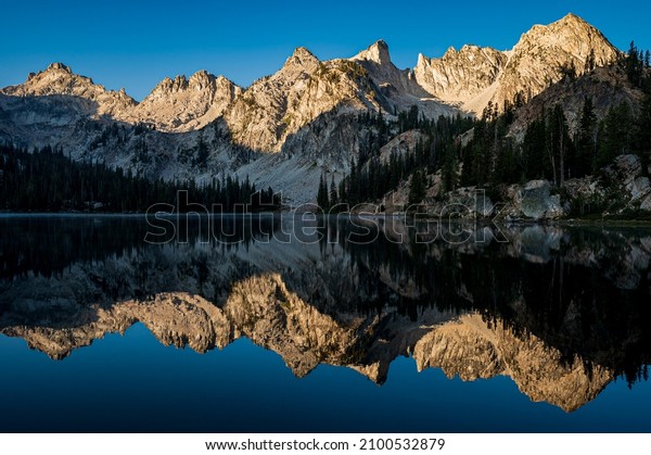 A mesmerizing view of the reflection of the\
Sawtooth Mountains in the  Alice\
Lake