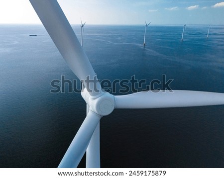 A mesmerizing view of windmill turbines generating clean energy in the vast expanse of the ocean, representing a harmonious blend of technology and nature.