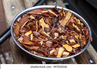 Mesquite Wood Chips Soaking For Smoking Meat On Barbecue. Barbeque Hickory Chunks Soaked For Grilling.