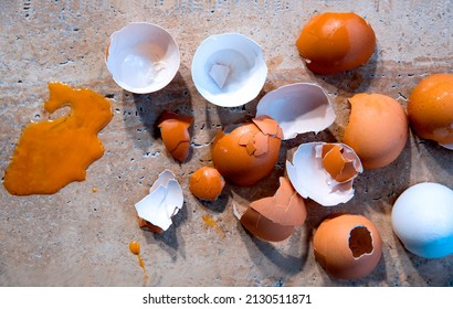 Mess Of Broken Eggs On The Kitchen Floor, With Egg Yolk Spill, Close Up. Save Organic Waste For  Natural Mulch