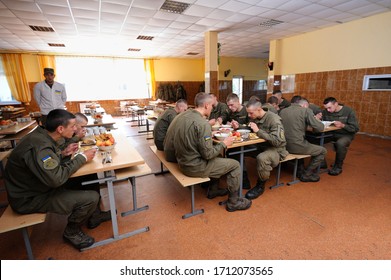 At A Mess Hall: Soldiers Sitting At Set-out Tables And Eating. Novo-Petrivtsi Military Base, Ukraine. November 12, 2018