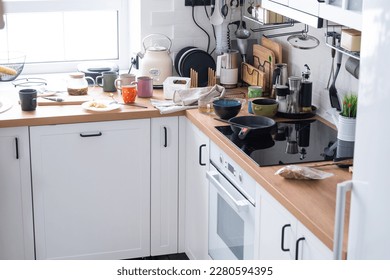 A mess in the kitchen, dirty dishes on the table, scattered things, unsanitary conditions. The dishwasher is full, the kitchen is untidy, everyday life