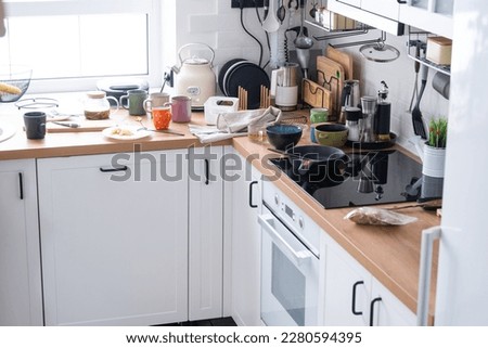 A mess in the kitchen, dirty dishes on the table, scattered things, unsanitary conditions. The dishwasher is full, the kitchen is untidy, everyday life