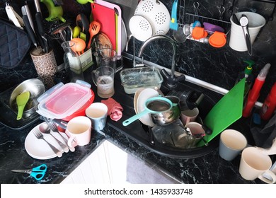 The Mess In The Modern Kitchen. No Washed Dishes, Pots And Pans In The Kitchen Sink. A Lot Of Dirty Dishes After Breakfast, Lunch And Dinner On The Table Top.