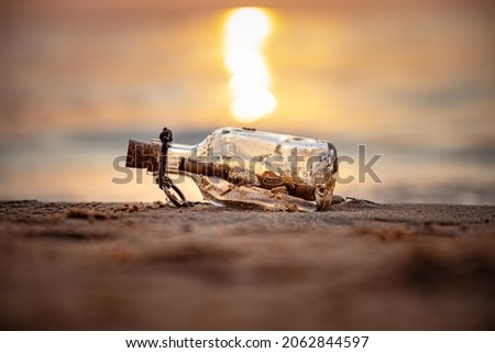 Message in the bottle against the Sun setting down