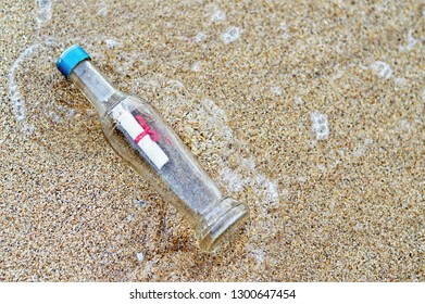 Message in a bottle on sand beach - Shutterstock ID 1300647454