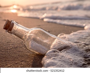 Flaschenpost an Land gewaschen gegen Sonnenuntergang