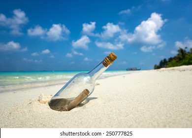 Message in a bottle washed ashore on a tropical beach. - Shutterstock ID 250777825