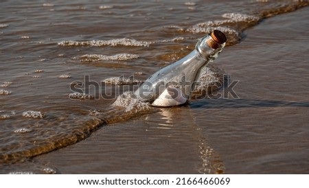 A message in a bottle washed up on the beach by waves