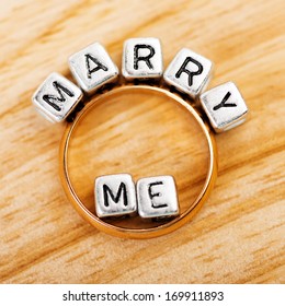 Message Marry Me Spelled In Matallic Blocks And Golden Ring