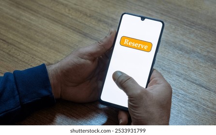 “Reserved” message on close-up smartphone screen. Online reservation. Office background. Hotel, vacation or event booking message. - Powered by Shutterstock