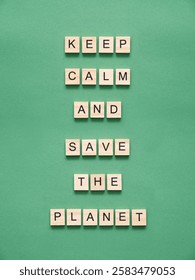 Message representing the concept of environmental awareness and concern for the future of the Earth, wooden pieces with letters form, on a green background, the text Keep calm and save the planet.